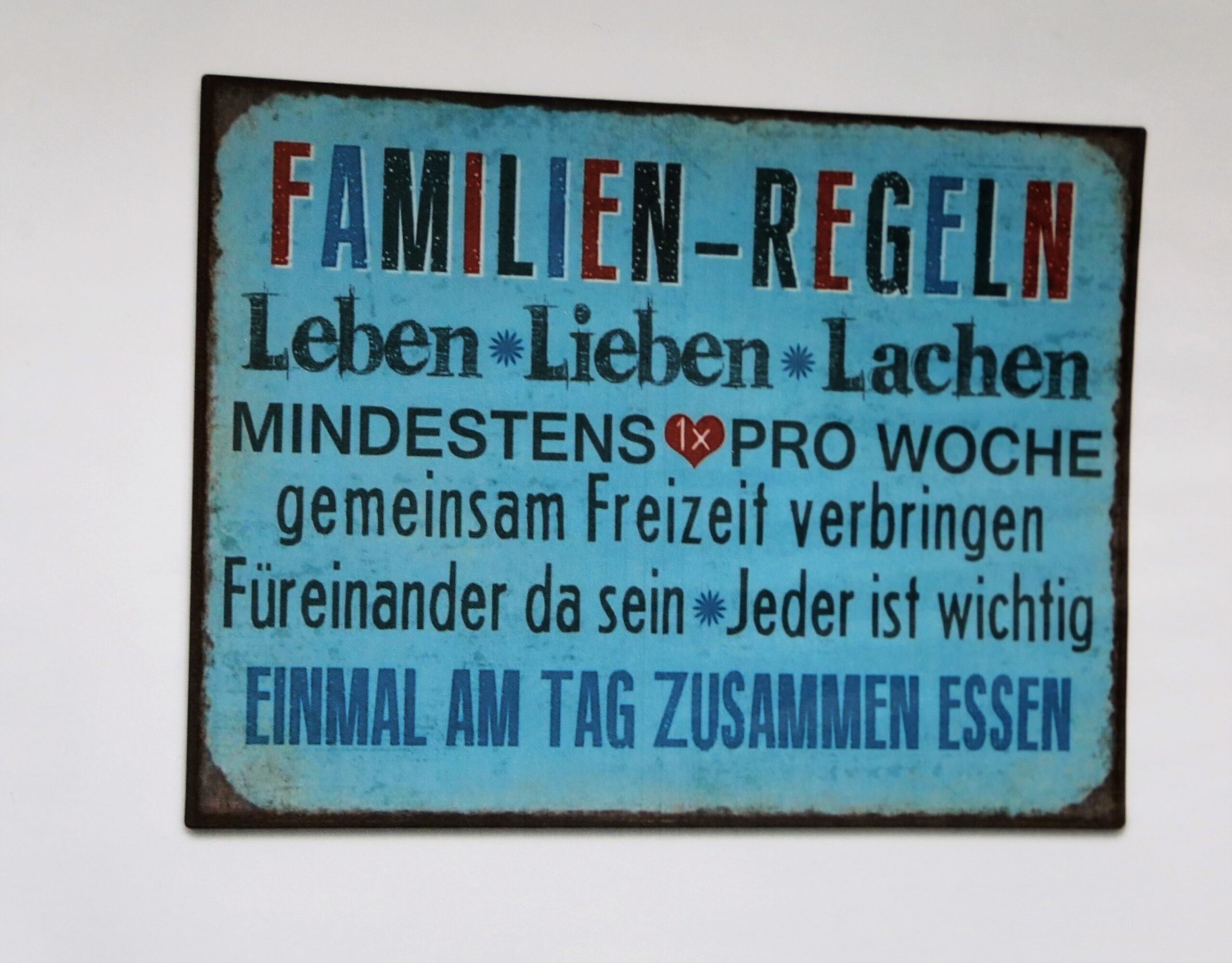 Ein Schild, auf dem die Familienregeln stehen: Leben, lieben, Lachen - mindestens einmal pro Woche gemeinsam Zeit verbringen. Für einander da sein. Jeder ist wichtig. Einmal am Tag zusammen essen.